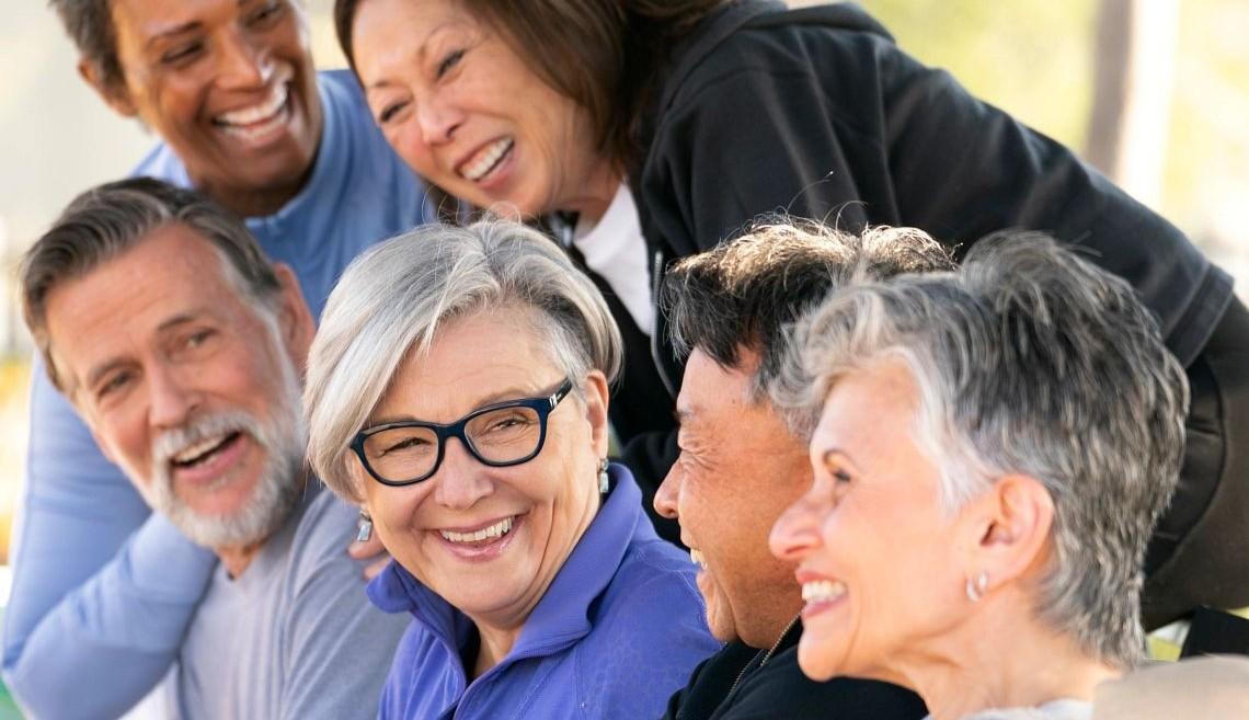 Photo of diverse group of older adult friends smiling or laughing