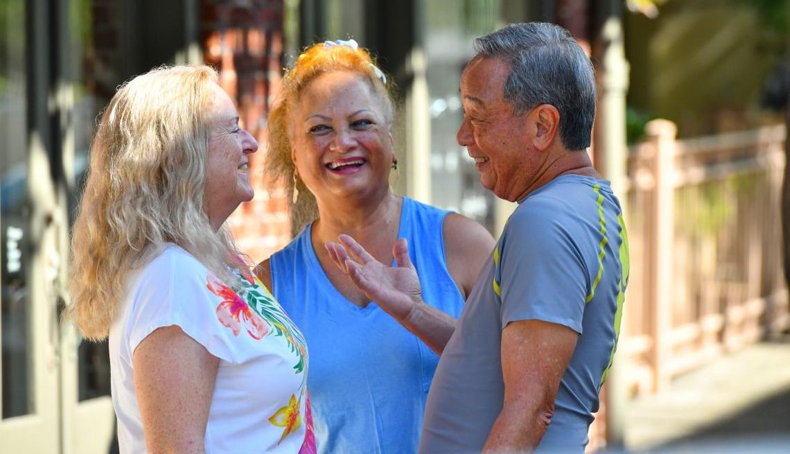 Three attractive older adults laughing together.